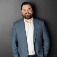 Jeff Nieman, COO of Merchants Fleet, in a gray jacket and button up shirt with a gray background.